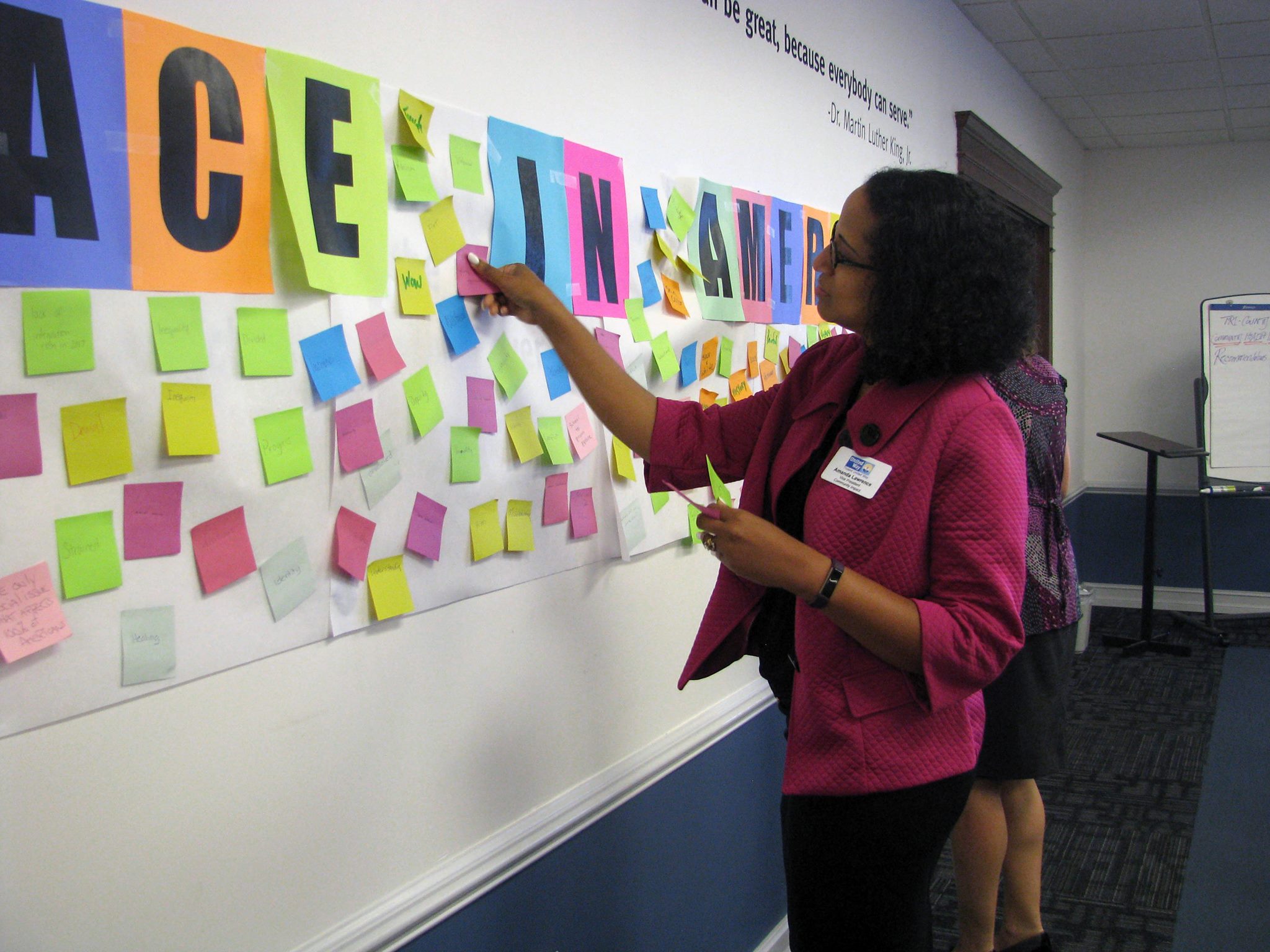 Each participant was asked to write 5-8 words that came to mind when they thought about Race in America. Trident United Way Vice President Amanda Lawrence attaches sticky notes containing the words on the wall.
